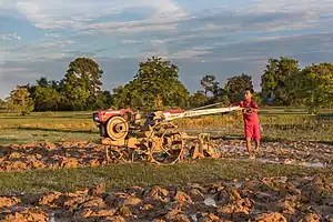 Boy plowing with a tractor at sunset on the island