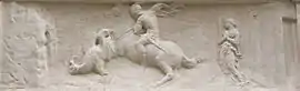 Stone bas-relief of a knight slaying a dragon in front of a princess